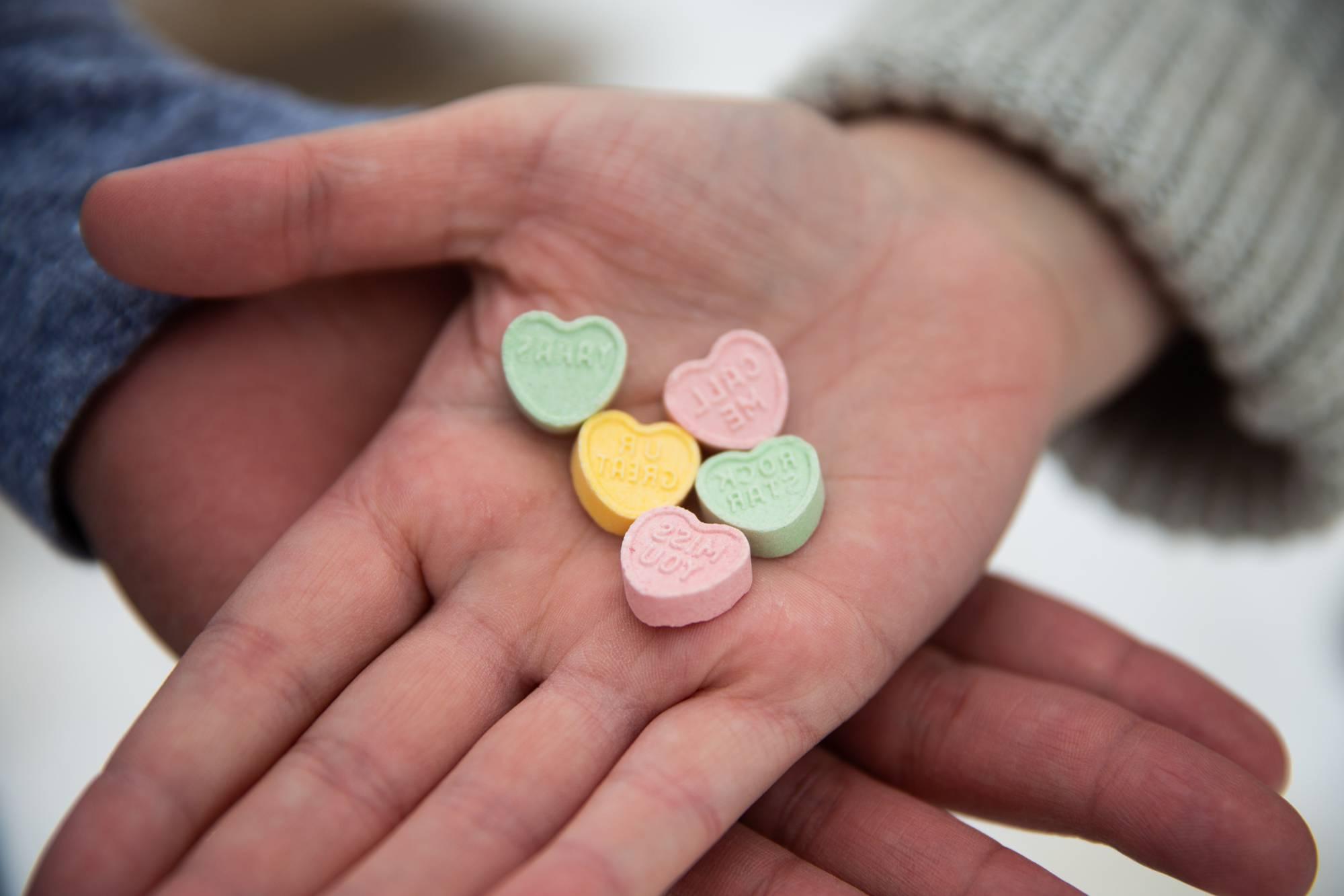 Couple holding heart shaped candies